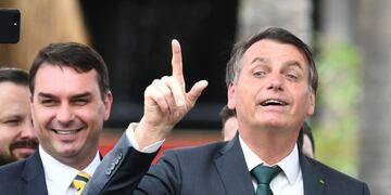 (FILES) In this file photo taken on November 21, 2019 Brazilian President Jair Bolsonaro (R) gestures next to his son, Senator Flavio Bolsonaro, during the launching of his new party, the Alliance for Brazil, at a hotel in Brasilia\u002E - Press organizations in Brazil rejected a judge's decision on September 4, 2020 of prohibiting TV chain Globo the release of documents regarding Flavio Bolsonaro's judicial process for alleged corruption for considering it is under secrecy order\u002E (Photo by EVARISTO SA / AFP)