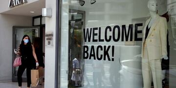 FILE - In this file photo dated Monday, May 4, 2020, a woman wearing a face mask exits from a shop along Makarios Avenue, a busy shopping street in central Nicosia, Cyprus\u002E Cyprus' government Wednesday May 27, 2020, is pledging to cover all costs for anyone testing positive for the coronavirus while on vacation in the east Mediterranean island nation, covering the costs of lodging, food, drink and medication for COVID-19 patients and their families\u002E (AP Photo/Petros Karadjias, FILE)