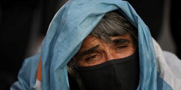 A man who identified himself as Marcos sits on an avenue with a pan asking for help as people protest around the Obelisk monument demanding the end of the government-ordered lockdown to curb the spread of the new coronavirus in Buenos Aires, Argentina, Thursday, July 9, 2020\u002E People protested across the country during the local Independence Day holiday, the handling of the pandemic by the administration of President Alberto Fernandez\u002E (AP Photo/Natacha Pisarenko)