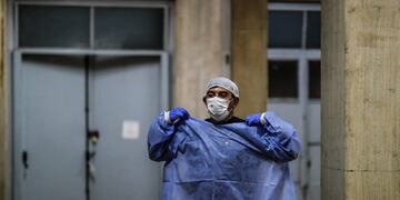 Un enfermero del Hospital Posadas se cambia su ropa de protección luego de realizar un traslado de un paciente con COVID-19, en Buenos Aires. (Foto: EFE/ Juan Ignacio Roncoroni)