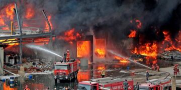 Lebanese firefighters try to put out a fire that broke out at Beirut's port area, on September 10, 2020\u002E - Thick black columns of smoke rose into the sky, as the army said it had engulfed a warehouse storing engine oil and vehicle tyres\u002E (Photo by ANWAR AMRO / AFP)