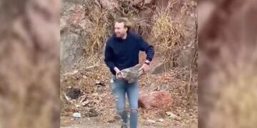 Imagen de un joven tirando una piedra de gran tamaño al embudo del Dique San Roque\u002E