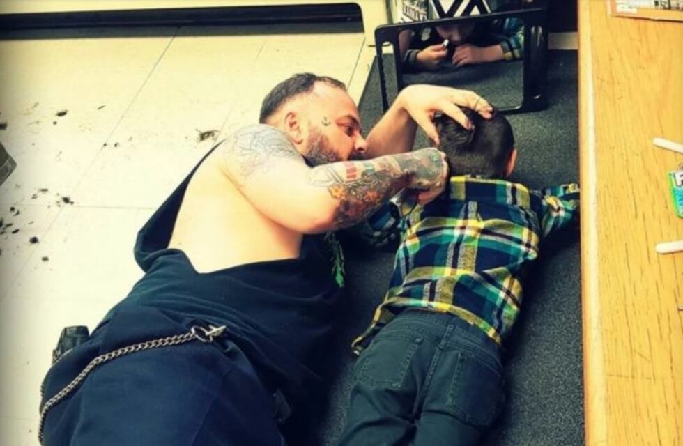 Un peluquero se tiró al piso para cortarle el pelo a un nene con autismo y se volvió viral