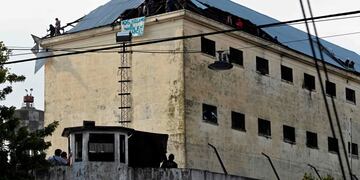 Inmates protest on the roof of Villa Devoto prison demanding measures to prevent the spread of the Covid-19 coronavirus, after a case was reported inside the detention center, in Buenos Aires on April 24, 2020\u002E (Photo by JUAN MABROMATA / AFP)