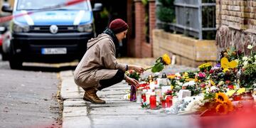 Una mujer coloca una flor frente a la sinagoga en Halle, Alemania, el 11 de octubre de 2019\u002E Crédito: EFE / EPA / FILIP SINGER\u002E