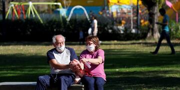 A couple wearing face masks disinfects hands in a park after restrictions were partially lifted for children in the city of Buenos Aires during the coronavirus disease (COVID-19) outbreak, Argentina May 16, 2020\u002E REUTERS/Agustin Marcarian