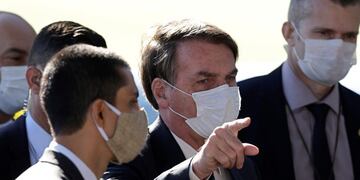 Brazil's President Jair Bolsonaro wears a face mask as he speaks to the press upon departure from the official residence of Alvorada palace in Brasilia, Brazil, Monday, May 11, 2020\u002E Starting Monday, the capital city's government will fine or jail those who do not wear a face mask in public, amid the spread of the new coronavirus\u002E (AP Photo/Eraldo Peres)