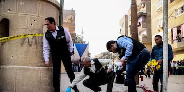 Egyptian security members and forensic police inspect the site of a gun attack outside a church south of the capital Cairo, on December 29, 2017\u002E\nA gunman opened fire on a church, killing at least nine people before policemen shot him dead, state media and officials said\u002E  / AFP PHOTO / Samer ABDALLAH