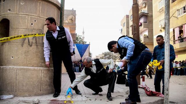 Egyptian security members and forensic police inspect the site of a gun attack outside a church south of the capital Cairo, on December 29, 2017\u002E\nA gunman opened fire on a church, killing at least nine people before policemen shot him dead, state media and officials said\u002E  / AFP PHOTO / Samer ABDALLAH