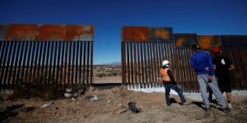 A worker chats with residents at a newly built section of the U.S.-Mexico border fence at Sunland Park, U.S. opposite the Mexican border city of Ciudad Juarez, Mexico January 26, 2017. REUTERS/Jose Luis Gonzalez