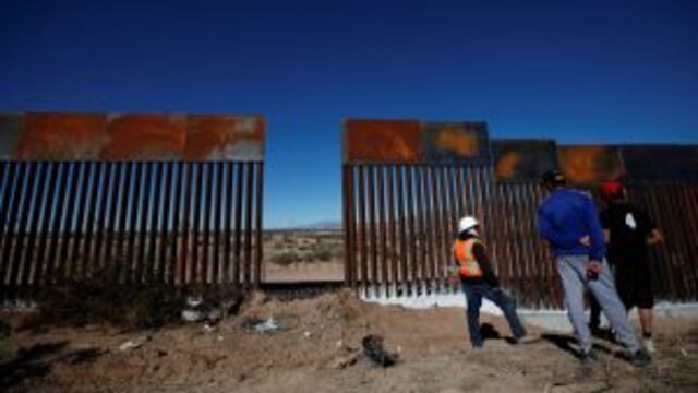A worker chats with residents at a newly built section of the U.S.-Mexico border fence at Sunland Park, U.S. opposite the Mexican border city of Ciudad Juarez, Mexico January 26, 2017. REUTERS/Jose Luis Gonzalez