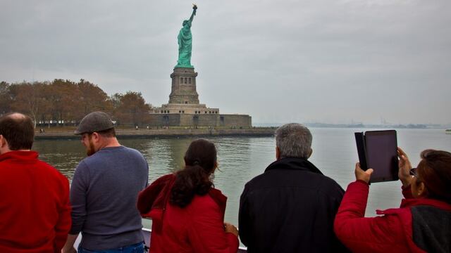 FILE - In this Nov. 5, 2015, file photo, visitors view the Statue of Liberty during a ferry ride to Liberty Island in New York. The U.S. Travel Association on Thursday, March 2, 2017, said there are