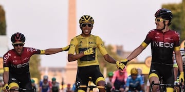 TOPSHOT - Spain's Jonathan Castroviejo (L) and Great Britain's Geraint Thomas (R) congratulate Colombia's Egan Bernal (C), wearing the overall leader's yellow jersey, as he celebrates his victory on the finish line of the 21st and last stage of the 106th edition of the Tour de France cycling race between Rambouillet and Paris Champs-Elysees, in Paris, in Paris on July 28, 2019\u002E (Photo by Anne-Christine POUJOULAT / AFP)