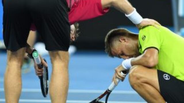 an Wawrinka of Switzerland consoles Martin Klizan of Slovakia (R) after winning the men's singles first round match on day one of the Australian Open tennis tournament in Melbourne on January 16, 2017.  / AFP PHOTO / WILLIAM WEST / --IMAGE RESTRICTED TO EDITORIAL USE - STRICTLY NO COMMERCIAL USE--