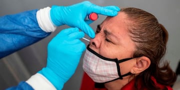 A health worker collects a swab sample from a woman to get her tested for COVID-19 in Nezahualcoyotl, Mexico state on July 13, 2020 amid the coronavirus pandemic\u002E - Mexico became on Sunday the fourth country with the most deaths in the world from the new coronavirus after overtaking Italy, according to an AFP report based on government sources\u002E (Photo by PEDRO PARDO / AFP) hisopado