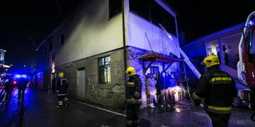 Firefighters stand outside the building of a local community centre where a fire killed eight people and injured 50 others in Vila Nova da Rainha in Tondela late on January 13, 2018\u002E / AFP PHOTO / Maria Joao Gala