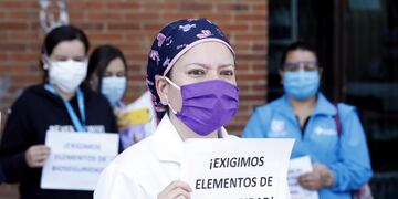-FOTODELDÍA- AME6746\u002E BOGOTÁ (COLOMBIA), 30/04/2020\u002E- Médicos y enfermeras del Hospital de Kennedy, uno de los más grandes de Bogotá, sostienen carteles durante una protesta pidiendo al Gobierno garantías laborales y elementos de protección adecuados para enfrentar la pandemia del coronavirus este jueves en Bogotá (Colombia)\u002E EFE/ Mauricio Dueñas Castañeda
