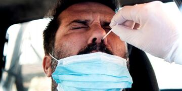 A man undergoes a swab test for coronavirus at a drive-through testing site of the Santa Maria della Pieta hospital in Rome on August 18, 2020\u002E - On August 16, Italy suspended its discos and ordered the mandatory wearing of masks from 6:00pm (1600 GMT) to 6:00am to clamp down on the spread of infection among young people, less than a month before the restart of school\u002E (Photo by Tiziana FABI / AFP)