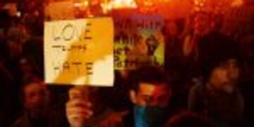 A demonstrator holds up a placard during a protest against Donald Trump's US presidential election victory, at City Hall in Portland on November 11, 2016.nDemonstrators took to the streets in Miami, Los Angeles, New York and other US cities to oppose Donald Trump's election as president for a third straight night of nationwide protests. / AFP PHOTO / Ankur Dholakia
