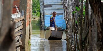 Un niño se transporta en una barca entre las calles inundadas en Cartagena, Colombia, por el paso del huracán Iota. (EFE)