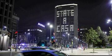 A police car patrols in downtown Milan, northern Italy, in front of the Lombardy region headquarters building where office lights have been left on to compose the Italian words 'State a casa' (Stay home), Wednesday, March 18, 2020\u002E Italian authorities say too many people are violating last week's national decree, which allows people to leave homes to go to workplaces, buy food or other necessities or for brief strolls outside to walk dogs or get exercise\u002E For most people, the new coronavirus causes only mild or moderate symptoms, such as fever and cough\u002E For some, especially older adults and people with existing health problems, it can cause more severe illness, including pneumonia\u002E(AP Photo/Luca Bruno)