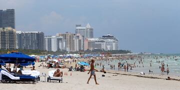 People walk on South Beach, Friday, Aug\u002E 28, 2015, in Miami Beach, Fla\u002E Tropical Storm Erika began to lose steam Friday as it skirted along the southern coast of the Dominican Republic, but it killed at least a dozen people killed on the small eastern Caribbean island of Dominica, authorities said\u002E Florida Gov\u002E Rick Scott declared a state of emergency for the entire state, which could begin seeing the effects of the system late Sunday and early Monday\u002E (David Santiago/El Nuevo Herald via AP) MAGS OUT; MANDATORY CREDIT miami eeuu gente en la playa playas de miami vista vistas de las playas tormenta tropical Erika perdio fuerza