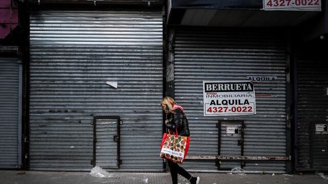 Una mujer camina frente a locales comerciales en el barrio de Once, hoy en Buenos Aires. (Foto: EFE/Juan Ignacio Roncoroni)