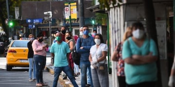 Gente esperando en las paradas los colectivos con demoras\u002E Transporte urbano Córdoba\u002E