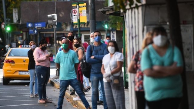 Gente esperando en las paradas los colectivos con demoras\u002E Transporte urbano Córdoba\u002E