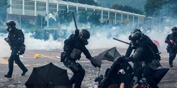 La policía golpea a manifestantes en el distrito de Sha Tin de Hong Kong el 1 de octubre de 2019, mientras se realizan manifestaciones violentas en las calles de la ciudad durante el feriado del Día Nacional para conmemorar el 70 aniversario de la fundación de la China comunista\u002E Crédito: ISAAC LAWRENCE / AFP\u002E
