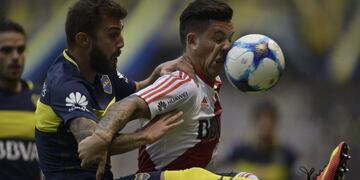 River Plate's forward Sebastian Driussi (R) vies for the ball with Boca Juniors' defender Gino Peruzzi during their Argentina first division football match at the La Bombonera stadium in Buenos Aires, on May 14, 2017. / AFP PHOTO / Juan MABROMATA
