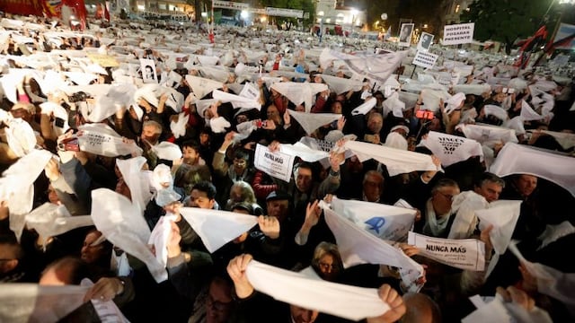 People raise white handkerchiefs, the signature symbol of the Mothers of Plaza de Mayo human rights group, during a protest against a Supreme Court ruling that benefited a man serving time for crimes against humanity in Buenos Aires, Argentina, Wednesday, May 10, 2017. In response to the popular outcry, earlier in the day Wednesday, Argentina's Congress approved a bill banning the reduction of jail sentences for people serving time for crimes against humanity. (AP Photo/Victor R. Caivano)