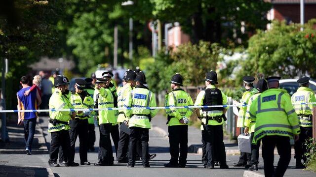 Police officers stand on duty on a cordoned-off road in Fallowfield, Manchester, in northwest England on May 23, 2017, as they search a resdiential property nearby following the May 22 deadly terror attack at the Ariana Grande concert at the Manchester Arena.nTwenty two people have been killed and dozens injured in Britain's deadliest terror attack in over a decade after a suspected suicide bomber targeted fans leaving a concert of US singer Ariana Grande in Manchester. / AFP PHOTO / Oli SCARFF