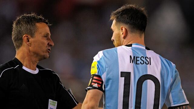 Argentina's forward Lionel Messi (R) argues with Brazilian first assistant referee Emerson Augusto de Carvalho during the half time of their 2018 FIFA World Cup Russia South American qualifier football match against Chile, at the Monumental stadium in Bue