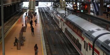 MADRID, 13/04/2020\u002E- Varias personas guardan la distancia social mientras esperan la llegada de su tren en los andenes de la estación de cercanías de Atocha-Renfe de Madrid este lunes, trigésima jornada del estado de alarma en el que gran parte de España vuelve a la actividad laboral tras la Semana Santa, pero el confinamiento se mantiene y el regreso al trabajo va acompañado del reparto de diez millones de mascarillas para combatir la pandemia del coronavirus\u002EEFE/ESPAÑA JuanJo Martín