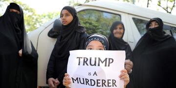 FILE PHOTO: A girl holds a sign reading “Trump is a murderer” during a condolence ceremony for Iranian Major-General Qassem Soleimani, who was killed in a airstrike near Baghdad, outside the Embassy of Iran in Kuala Lumpur, Malaysia, January 7, 2020\u002E REUTERS/Lim Huey Teng/File Photo