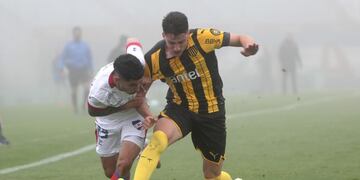 JJPANA3220\u002E MONTEVIDEO (URUGUAY), 09/08/2020\u002E- Santiago Rodríguez (i) de Nacional disputa el balón con Joaquín Piquerez de Peñarol en un partido de la cuarta fecha del Torneo Apertura entre Club Nacional y Peñarol hoy, en el estadio Centenario en Montevideo (Uruguay)\u002E El fútbol uruguayo reinició después de cuatro meses y veintitrés días suspensión por la emergencia sanitaria de la COVID-19\u002E EFE/Federico Anfitti