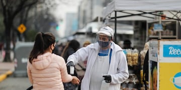 AME3622\u002E BUENOS AIRES (ARGENTINA), 20/07/2020\u002E- Un hombre toma la temperatura al ingreso a una feria de alimentos este lunes el primer día de la flexibilización de la cuarentena obligatoria por el COVID-19 en Buenos Aires (Argentina)\u002E La ciudad de Buenos Aires y su populosa área metropolitana (AMBA), junto a otras localidades con alta circulación de coronavirus, entraron este lunes en una etapa de la cuarentena más flexible, que contempla la apertura progresiva de actividades comerciales y habilita las salidas recreativas, todo sujeto a protocolos\u002E EFE/Juan Ignacio Roncoroni