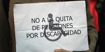 A woman holds a banners reading \