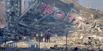 Personas examinan los daños después del bombardeo de un centro comercial, en Kiev, Ucrania. Ocho personas murieron en el ataque. (AP)