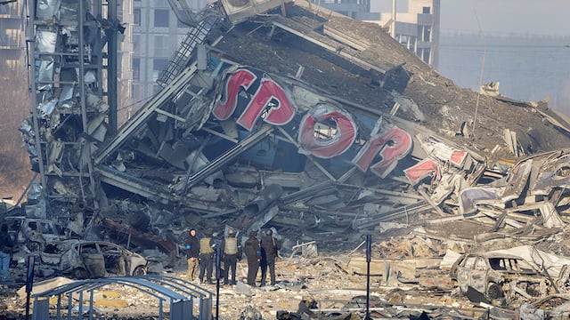 Personas examinan los daños después del bombardeo de un centro comercial, en Kiev, Ucrania. Ocho personas murieron en el ataque. (AP)