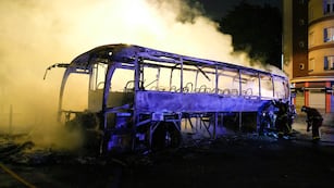 Bomberos arrojan agua a un autobús quemado, el sábado 1 de julio de 2023, en Nanterre, en las afueras de París, Francia. (AP Foto/Lewis Joly)