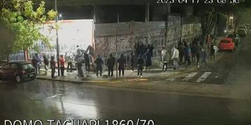 El grupo de personas, pegando los afiches que escrachaban a Clarín.