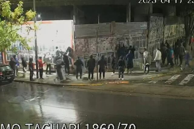 El grupo de personas, pegando los afiches que escrachaban a Clarín.