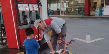 Foto viral del estacionero atendiendo a un niño en la Estación Marther Arroyito