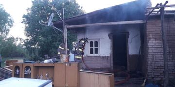 Bomberos trabajan sofocando el fuego que afectó una humilde vivienda en el distrito de Cañada Seca