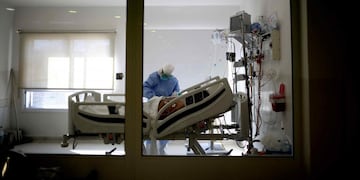 Un paciente internado con coronavirus es atendido por un trabajador de la salud. (Archivo)