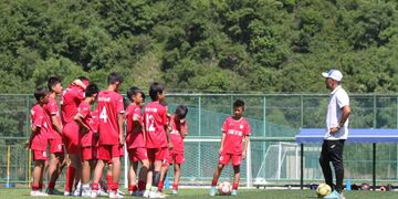 Nahuel Oyola hablando con sus pequeños dirigidos en el entrenamiento en su escuela de fútbol en China
