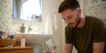 Hombre en el baño con el celular.