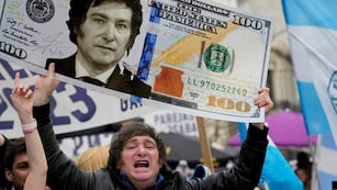 Javier Milei y un dólar con su cara. (AP)
